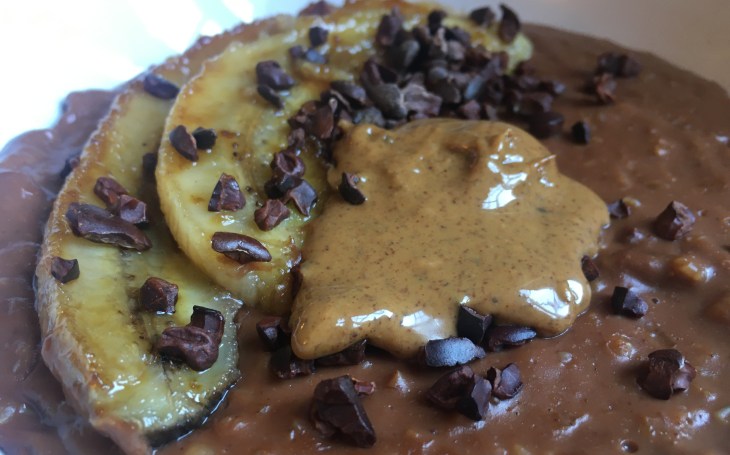 Chocolate porridge with caramelised banana, cacao nibs, and almond butter
