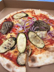 close up of Mamma Mia's vegan pizza topped with courgette and aubergine slices, artichoke, peppers and red onion.