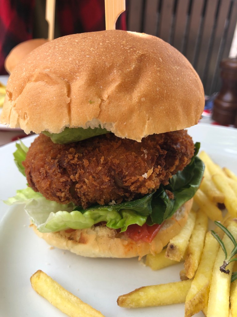Deep fried almond and courgette vegan burger in a brioche bun with rosemary fries from The Punter pub in Oxford.