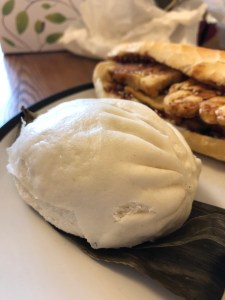 white spherical steamed bun with half tofu baguette in the background.
