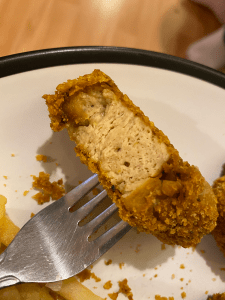 crispy vegan chicken bite cut in half to show meaty textured inside.