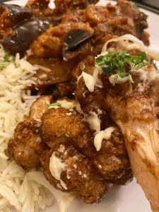 Cauliflower florets, golden brown from frying, with tahini drizzle, on a bed of rice.